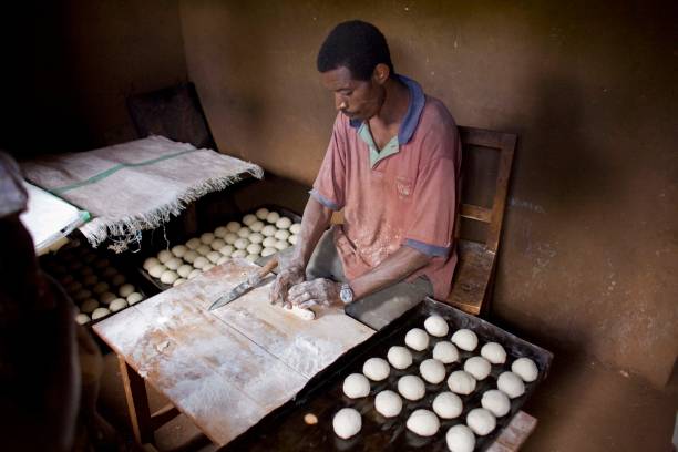 Microfinance loan recipient rolling dough for baking biscuits Burundi East Africa