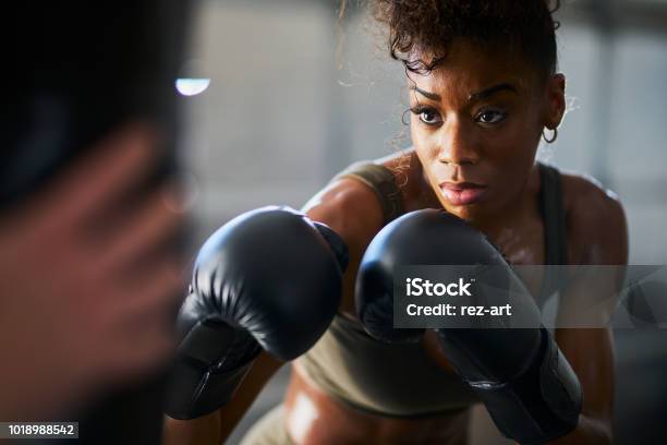 African Woman Boxing With Punching Bag In Garage Gym Stock Photo - Download Image Now