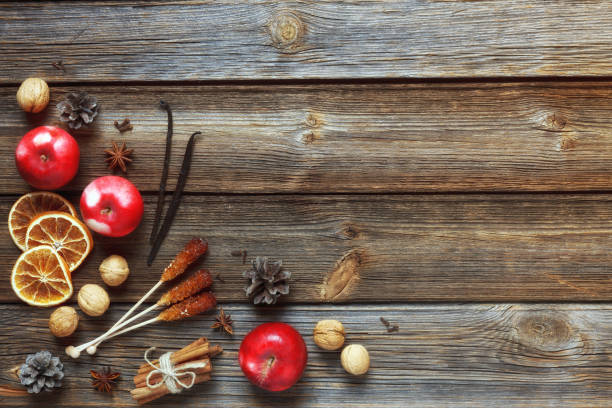 istock Christmas composition with red apples, walnuts, cinnamon and  other ingredients and accessories for the celebration of Christmas and New Year. Close-up, top view on rustic wooden background 1018990698