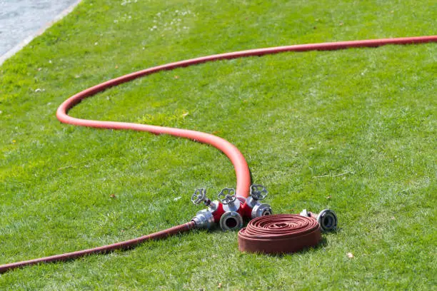 several red firehoses with connector piece