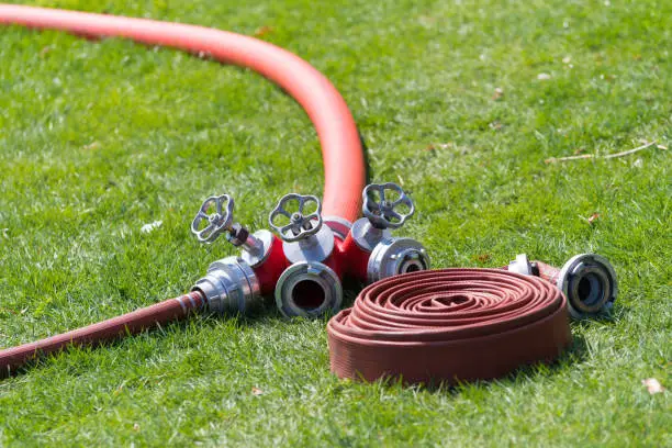 several red firehoses with connector piece