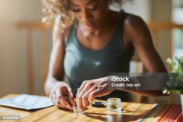 Woman At Home Rolling Marijuana Joint From Dispensary Bought Weed Stock Photo - Download Image Now