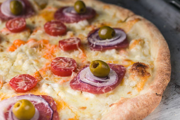 istock Italian pizza with cheese and olives on a baking sheet. Close-Up 1019000950