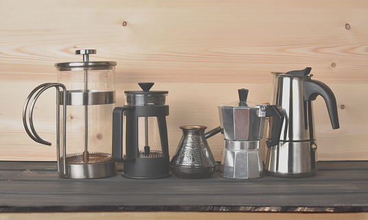 Old coffee makers on a wooden shelf. Vintage toned