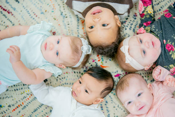 Babies group A group of babies are in a daycare centre. They are lying in a circle with their heads touching. group of babies stock pictures, royalty-free photos & images