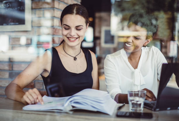istock Two Young Businesswomen Working at a Cafeteria 1019025970