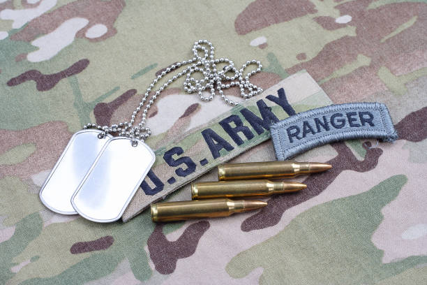 istock US ARMY ranger tab, flag patch,  with dog tag and 5.56 mm rounds on camouflage uniform 1019026316
