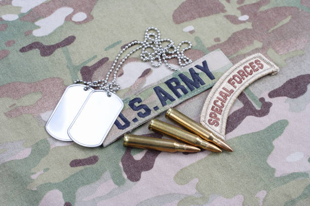 istock US ARMY special forces tab, flag patch,  with dog tag and 5.56 mm rounds on camouflage uniform 1019026438
