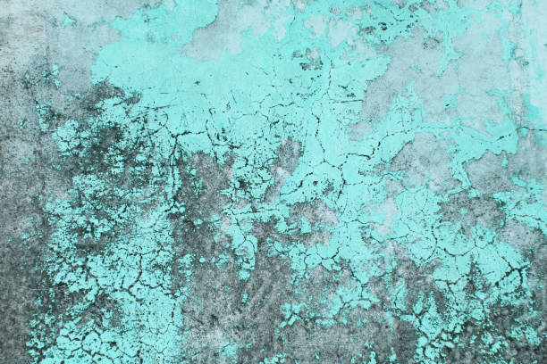 Old flaky paint peeling off grungy cracked wall. Cracks, scrapes, peeling old paint and plaster on background of old cement wall. An old cement stone blue wall vintage cracked. Design with copy space.