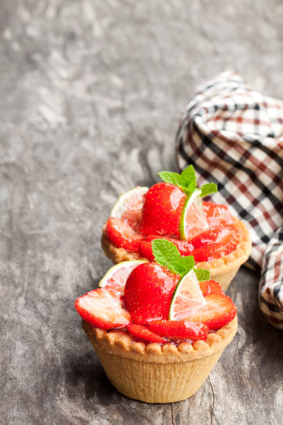 istock Egg custard  tarts with fresh strawberry and lime on wooden table 1019051010