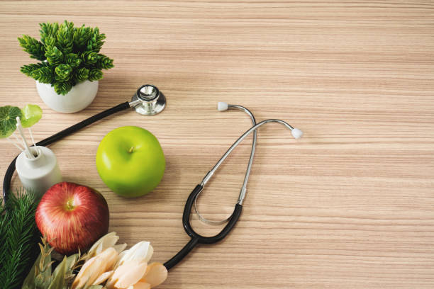 istock Stethoscope with apple fruits on wood background. 1019053088