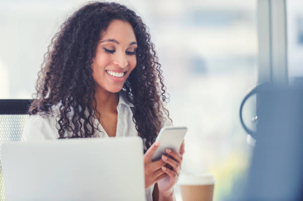 istock African American woman text messaging at her desk. 1019081816