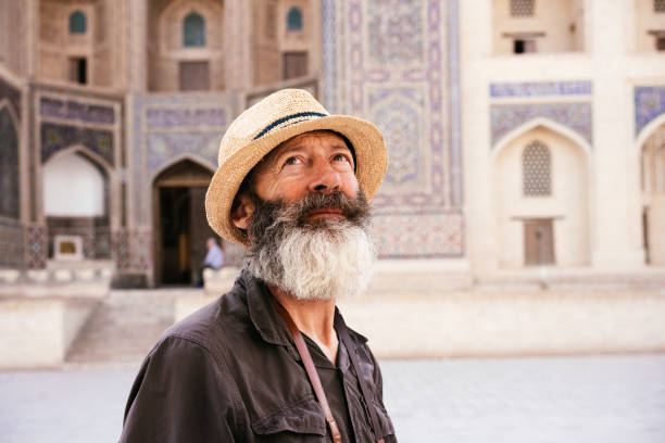 A senior man is looking up at the architectural structures.