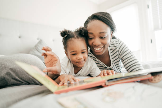 fiabe che i bambini amano - child reading mother book foto e immagini stock