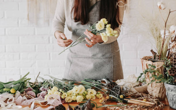 kobieta kwiaciarnia zbiera bukiet zdobi różne kwiaty - florist zdjęcia i obrazy z banku zdjęć