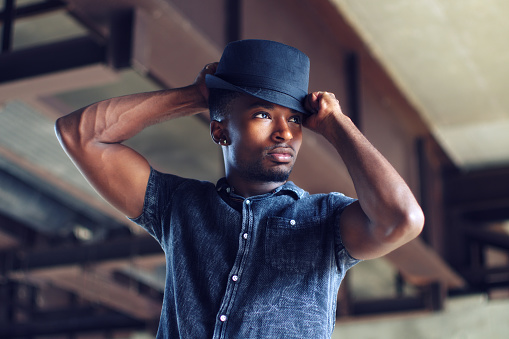 man putting on hat confident people successful person handsome guy