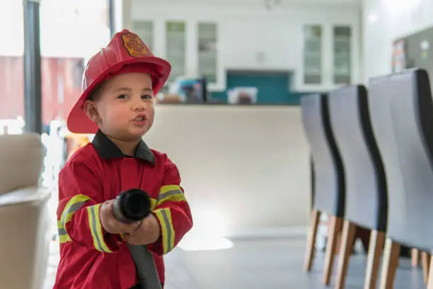 Photo of Little boy pretending to be a fireman