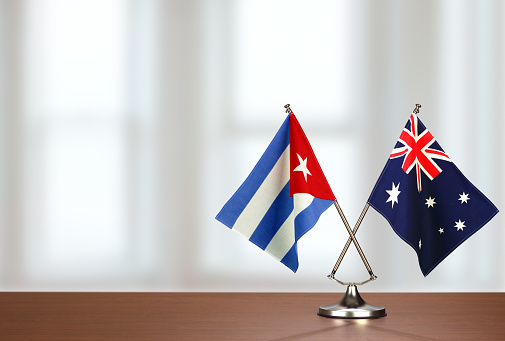 Two crossed national flags on wooden table
