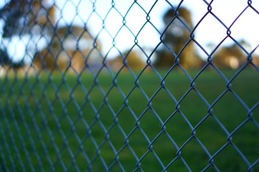 Chain link fence with blurred background of empty park