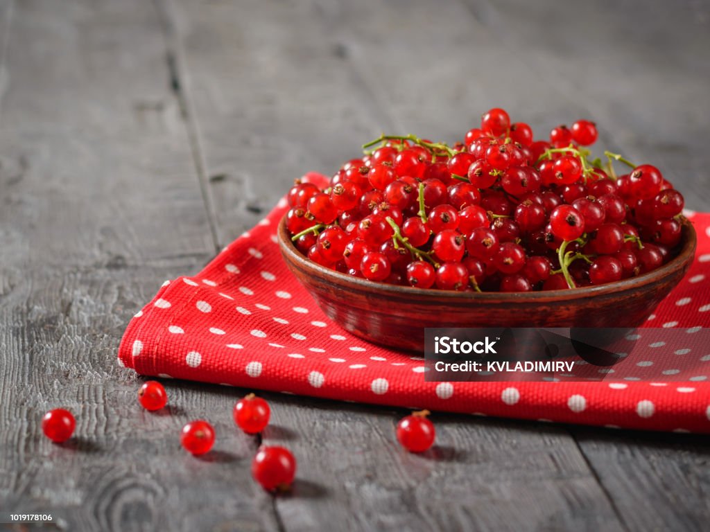 Bol d’argile avec raisins de Corinthe sur un tissu brillant sur une table rustique. - Photo de Aliment libre de droits