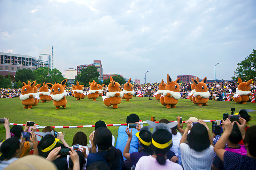 Tokyo, Japan - August 12, 2018: Pocket Monster performance - Eevee's parade at the fifth 'Pikachu Outbreak' on the lawn near Red Brick Warehouse in Yokohama. A lot of people from all over the world enjoying the show.