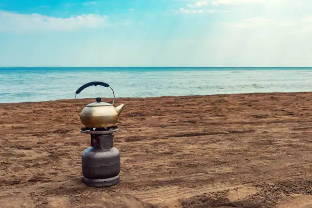 Boiling tea on a gas bottle by the sea