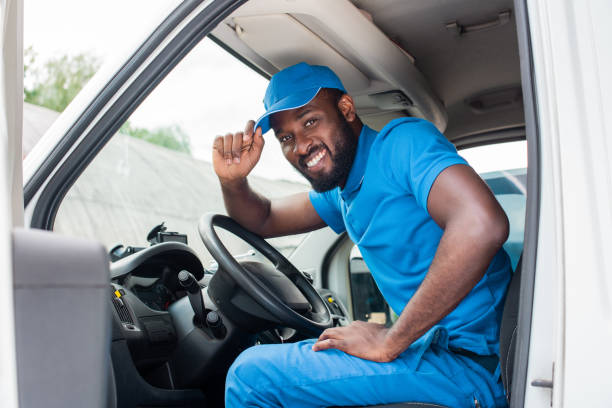 istock african american delivery man greeting and touching cap in car 1019214040
