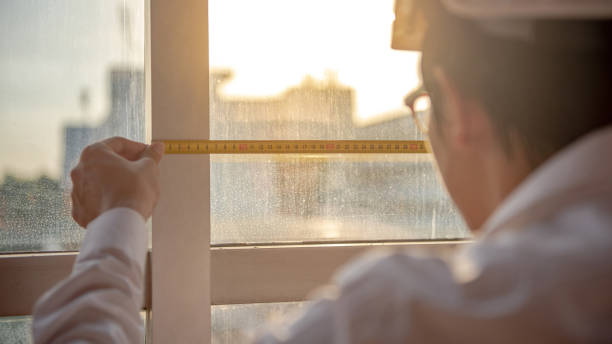 istock Young Asian engineer man using tape measure (measuring tape) on window frame at construction site, Length measurement tool or equipment for building construction working 1019216822