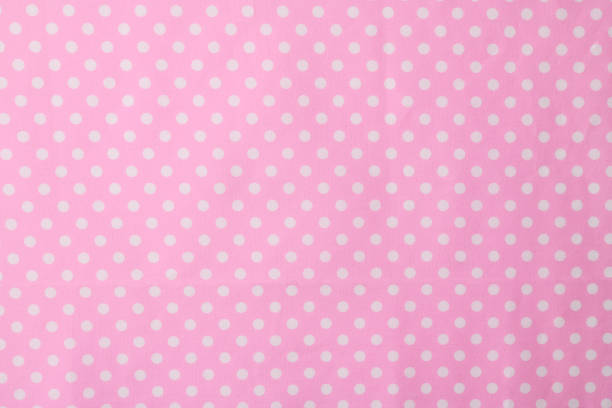 istock Close-up of pink polka dot fabric texture background 1019217376