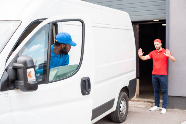 istock multiethnic delivery men in uniform parking white van on street 1019217438