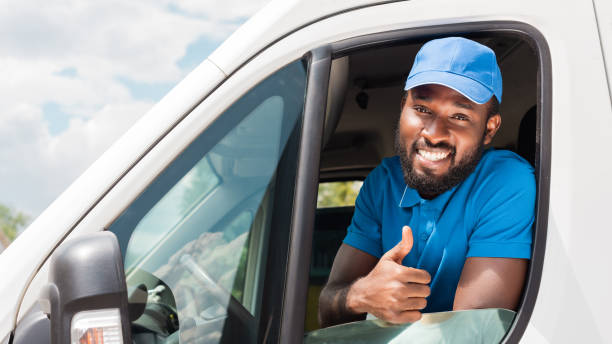 istock smiling african american delivery man showing thumb up from van 1019217456
