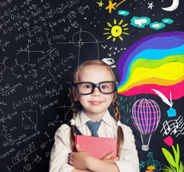 istock Little girl student on blackboard background with chalk math and colorful art pattern. Creativity education, arts and science, right and left hemispheres of the brain concept 1019219714