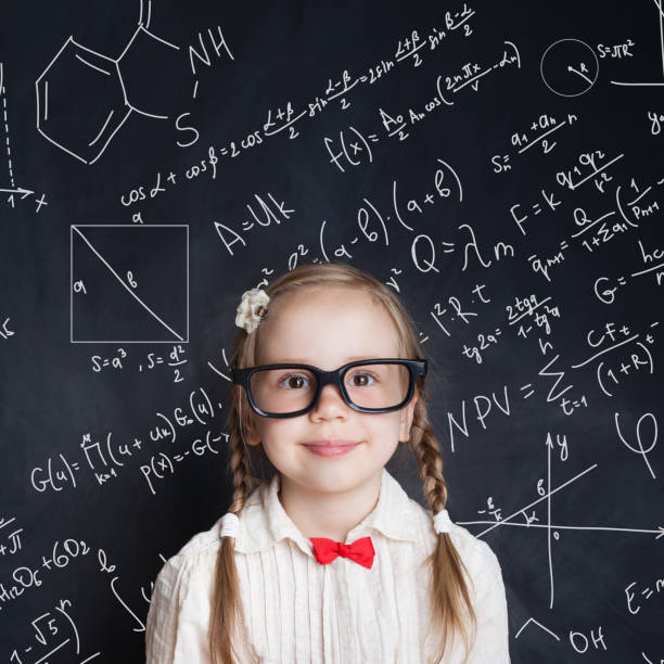 istock Little genius. Smart little girl math student on school blackboard background with hand drawings science formula pattern. Kids mathematics education concept 1019219742