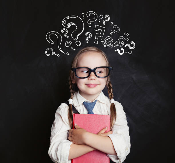 istock Cute child schoolgirl with question marks and book 1019219884