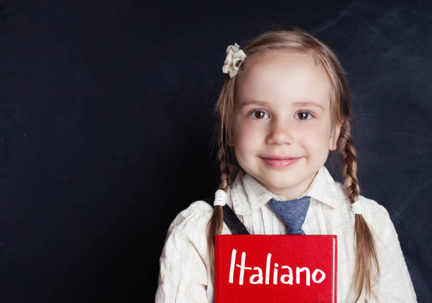 istock Smiling child student learning italian at the classroom chalkboard banner background with copy space 1019220186