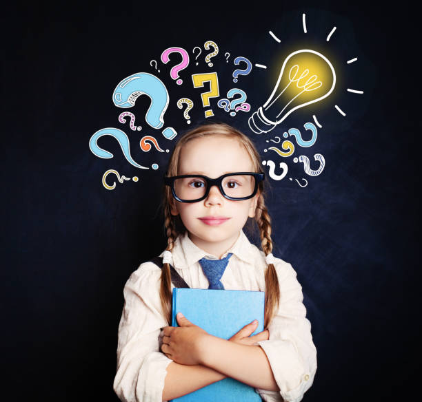 istock Cute child schoolgirl at the blackboard with lightbulb and colorful question marks. Problem and solution. Ideas concept 1019220370