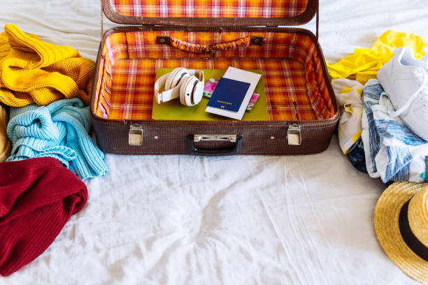 istock suitcase with winter and summer clothes on bed. preparing for trip. suitcase with garment. travel concept 1019220664
