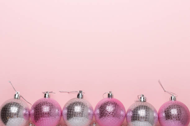 istock Pink and silver christmas balls on a paper background 1019241674