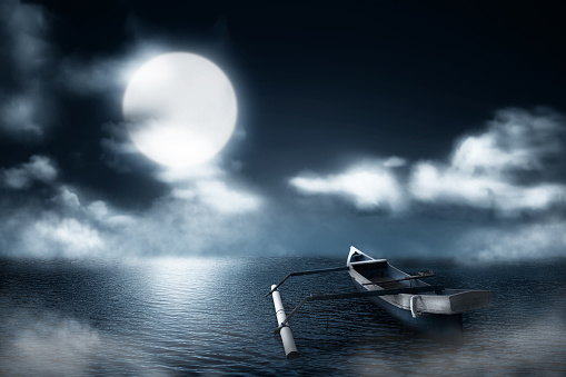 Wooden boat on the misty lake at night