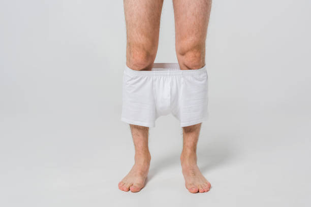 istock cropped shot of man with slipped down white underwear on grey backdrop 1019241690