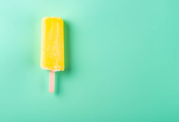 istock yellow popsicle on a light green background 1019252134