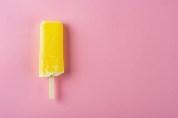 istock yellow popsicle on a pink background 1019252322