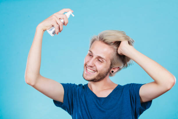 istock Man applying spray cosmetic to his hair 1019262402