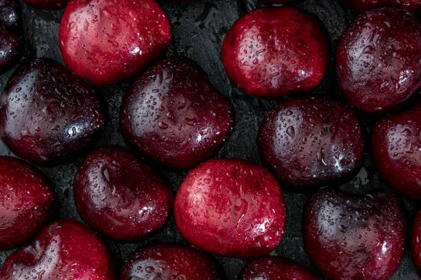 istock Precious red and fresh cherry pints, fresh and raw on a textured and veined black background. 1019262568