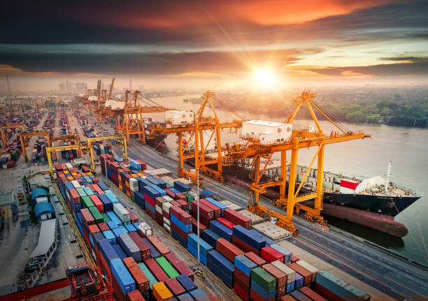 istock Logistics and transportation of Container Cargo ship and Cargo plane with working crane bridge in shipyard at sunrise, logistic import export and transport industry background 1019283130
