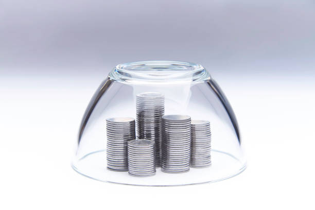 istock Stacks of stacked silver coins under a glass dome. 1019302402