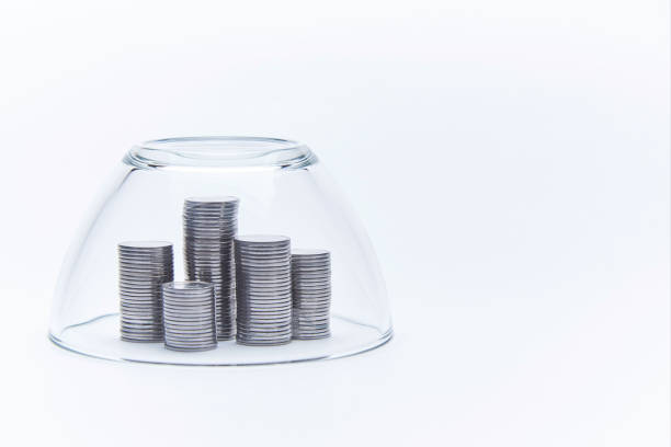 istock Stacks of stacked silver coins under a glass dome. 1019302444
