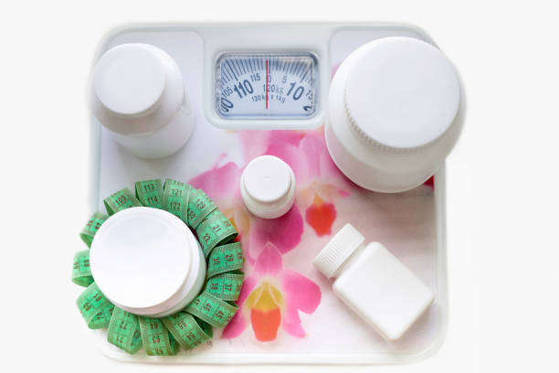 istock White clean jars with a centimeter tape lie on the scales. 1019302476