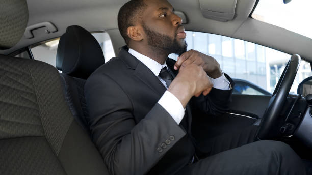 Handsome black man in business suit looking in car mirror, ready for date Handsome black man in business suit looking in car mirror, ready for date man adjusting tie stock pictures, royalty-free photos & images