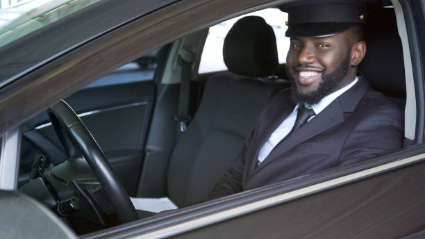 Happy African American chauffeur looking into camera, luxury transfer, service